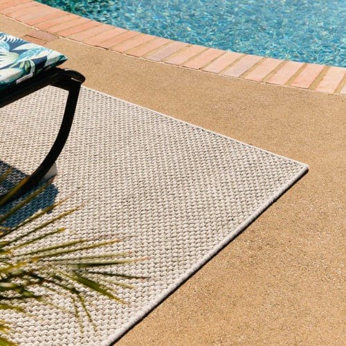 Beachfront Glacial Loop serged outdoor area rug by swimming pool