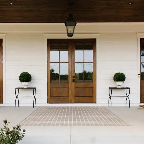 Sandpoint Beige Plaid outdoor area rug on front porch
