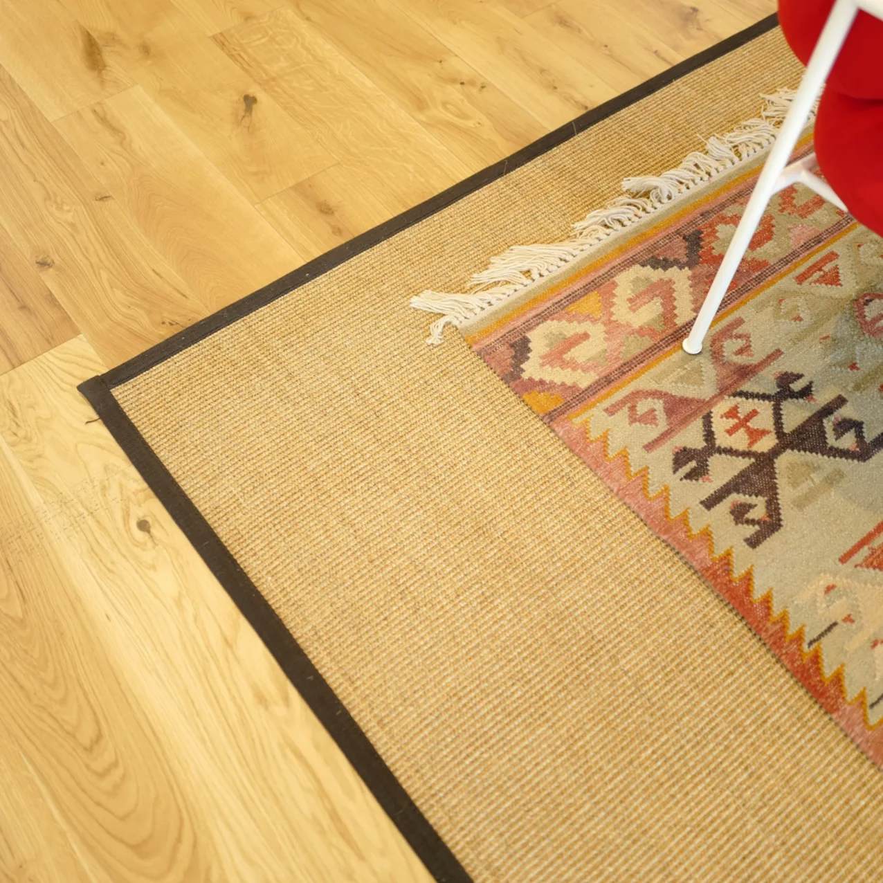 Livos Lodge sisal rug with black cloth border and layered rug on top