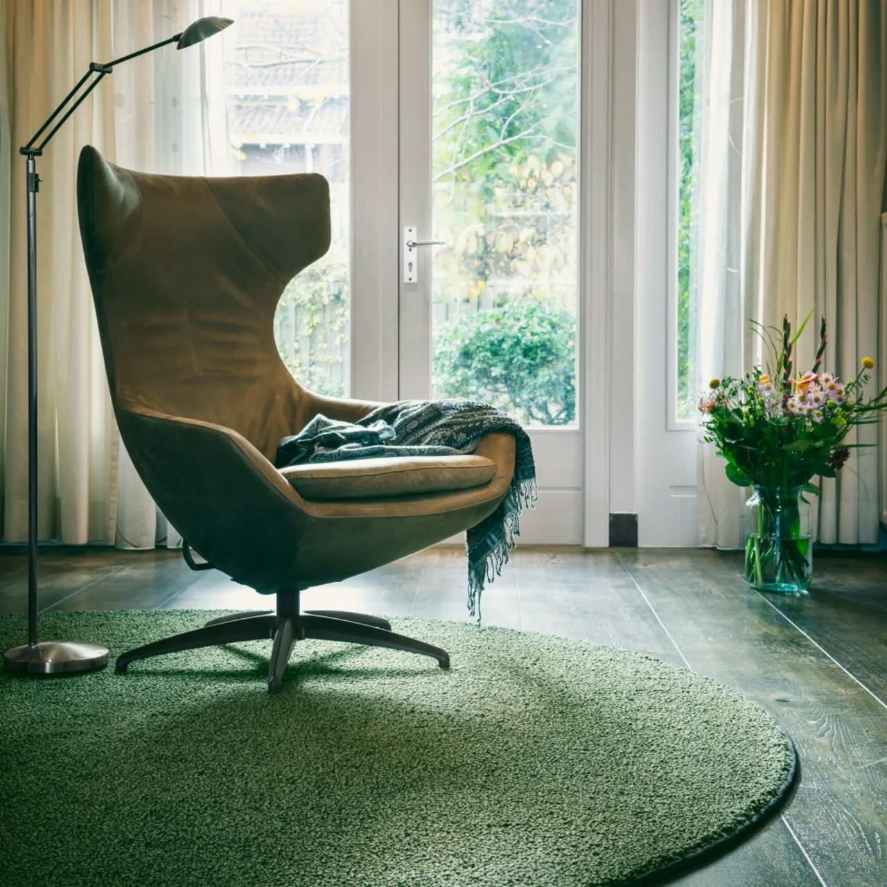 Fingers Crossed Flavoured Olive circular wool rug in sitting room with modern lounge chair