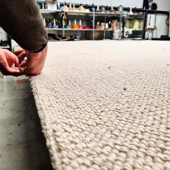 Artisan from Best Wool finishing a wool rug.